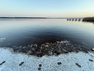 sunset on the lake in winter season with frozen ice floes 
