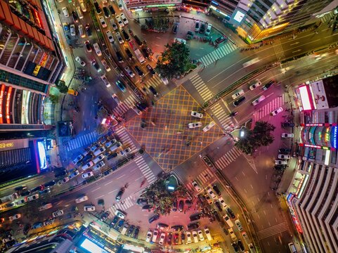 Aerial view of a bustling intersection alive with the vibrant glow of streetlights and car headlights, illuminating the city's energetic pulse, Dhaka, Dhaka Division, Bangladesh.