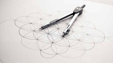 Geometry compass drawing intricate geometric patterns on paper  