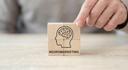 Adult hand placing a wooden block to complete a neuromarketing puzzle on a light wood desk, indoor office setting, consumer psychology and brain research concept.