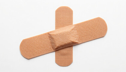 Two beige adhesive bandages crossed over each other on a white background, representing medical care and healing