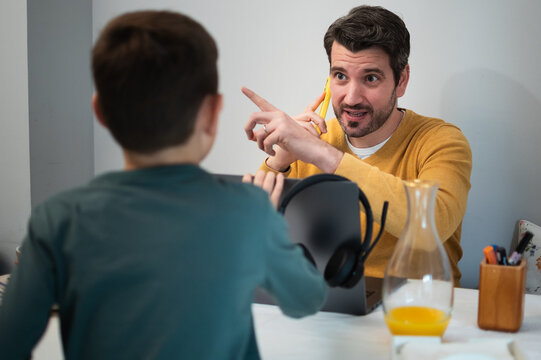 Busy father on phone while son interrupts during remote work