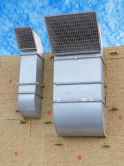 Two industrial ventilation pipes on a wall