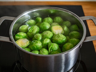 Cooking Brussels sprouts in pot on electric stove