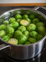 Cooking Brussels sprouts in pot on electric stove
