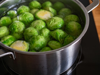 Cooking Brussels sprouts in pot on electric stove