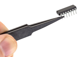 Tweezers hold a chip on a white