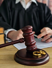 Court session with judge in robe overseeing divorce proceedings with wedding rings