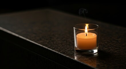 A silent memorial flame burning with a warm glow on a dark granite surface, representing a solemn remembrance and peace concept for the Day of Remembrance for Genocide Victims