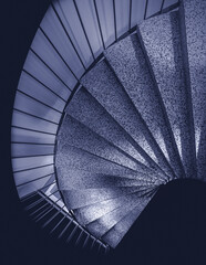Abstract spiral staircase from above in monochrome blue tone.