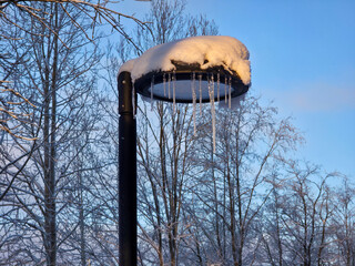 A street lamppost in winter with icicles