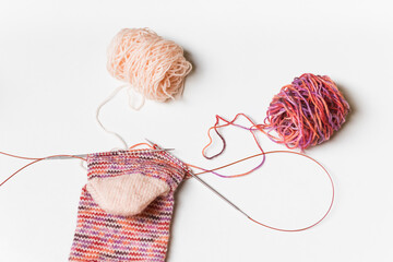 Hand knitting wool socks on white background. Process of knitting. Hand made.