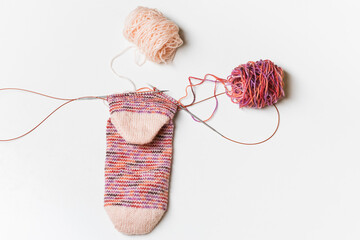 Hand knitting wool socks on white background. Process of knitting. Hand made.