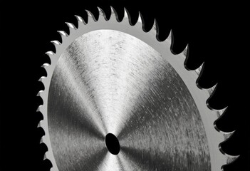Close-up of circular saw blade with sharp teeth on black background