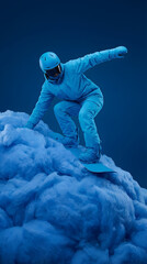 Snowboarder en tenue int&eacute;grale bleue effectuant une figure sur une montagne de laine ou de coton bleu sur un fond studio uni