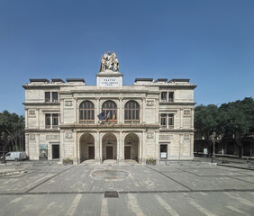 Obraz premium Messina, Sicily, Italy - July 18, 2024: Downtown scenery. Teatro Vittorio Emanuele is a historic building with a giant angel statue on top along Via G. Garibaldi.