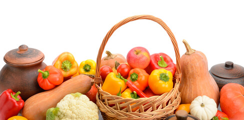 Rustic kitchen composition with seasonal vegetables, fruits and clay pots isolated on white