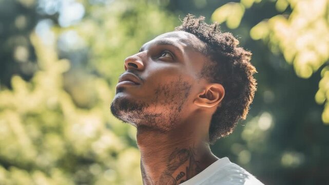 of a young man in the park, gazing into the distance with a contemplative look. - Powered by Adobe