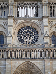 Obraz premium The intricate facade of Notre-Dame de Paris, with the massive rose window and the a row of statues below representing the Kings of Judah. Gothic architecture with delicate stone tracery and carvings