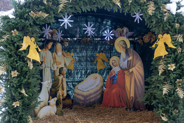 Moscow, Russia,  Large outdoor Nativity scene with golden-painted figures of Mary, Joseph, baby Jesus, shepherds, angels, and animals framed by evergreen arches and stars.  Novospassky Monastery ​