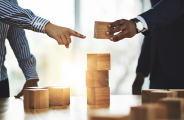 Business, hands and people with wooden blocks for building startup company, synergy or cooperation. Pointing, team and stack tower in office for partnership, development process or strategic planning