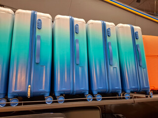 Suitcases are sold in supermarket. Large suitcases are on counter in store