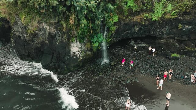 Circular Drone Orbit Around Waterfall on Black Volcanic Beach in Seixal, Madeira