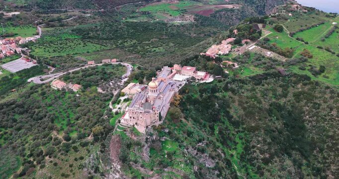 Aerial view of the Sanctuary of Tindari, a pilgrimage church atop a cliff, with winding roads and the town visible in the background, Tindari, Sicily, Italy.