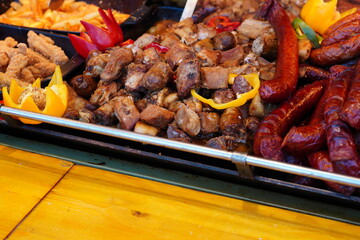 Fried pork meat and sausages for sale at Cristmas market in Bucharest. Savory Romanian traditional food.