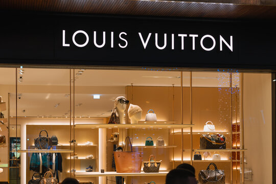 bright, elegant louis vuitton store window display showcasing luxury handbags, accessories, and products inside. a perfect image for luxury and fashion themes.