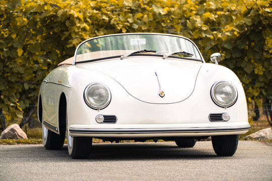 1957 Porsche 356 Speedster replica cream classic car convertible sunny day parked leafy background