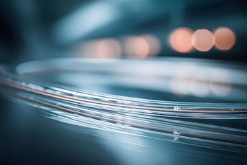 Close view of transparent wires on a dark surface with blurred lights in the background