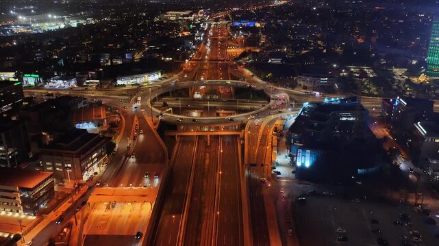 Aerial drone night video of illuminated multilevel ring road junction crossing Attiki Odos and National motorway in Northern Athens, Attica, Greece