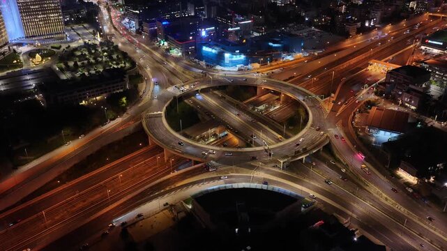 Aerial drone night video of illuminated multilevel ring road junction crossing Attiki Odos and National motorway in Northern Athens, Attica, Greece