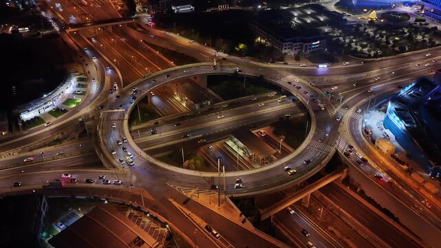 Aerial drone night video of illuminated multilevel ring road junction crossing Attiki Odos and National motorway in Northern Athens, Attica, Greece