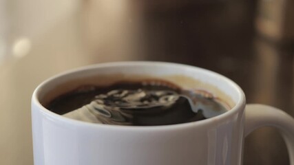 Slow Motion Hand Dropping Sugar Cube Into Black Coffee. Sugar Falling Down Into Coffee Cup. Coffee Caffeine Addiction Junk Food. Concept of Unhealthy Eating, Diabetes, Obesity, Heart Disease. - Powered by Adobe