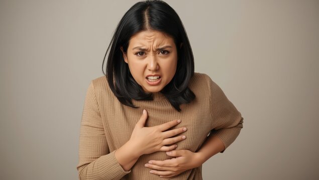 Asian woman in pain from overeating durian, experiencing stomach issues and discomfort from indigestion