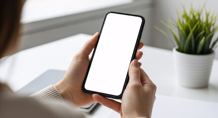 Woman holding smartphone with blank screen against blurred office background