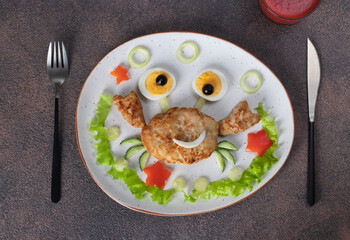 A fun breakfast idea for kids: crab-shaped turkey cutlet with eyes made from boiled egg and olives, Top view