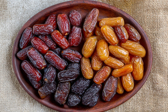 Dates or dattes palm fruit in wooden bowl is snack healthy, Set of various dates in bowl, Different kind of raw date fruit ready to eat, concrete background, Traditional, delicious and healthy ramadan