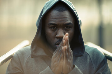 Adult man looking determined in hoodie at outdoor gym