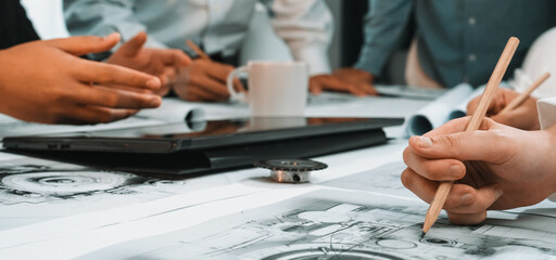 Engaged team members discuss project plans during a collaborative meeting. A creative workspace with sketches, a laptop, and coffee encourages productivity and innovation. SACTR