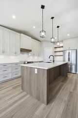 Kitchen with a white island and a silver refrigerator