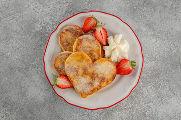 Valentine's Day breakfast: heart-shaped French toast with strawberries and whipped cream on a plate. Romantic brunch dessert. Top view, copy space.?