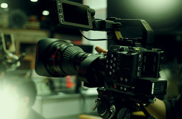 Behind the scenes of movie shooting or filming or video production with high quality camera and tripod equipment set up and professional film crew team in studio lighting. Video production camera gear