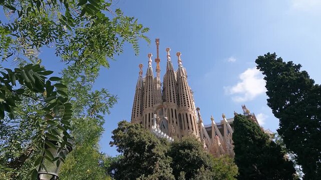 Majestic architectural design of Sagrada Familia cathedral in Barcelona, Spain, framed by greenery