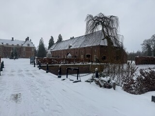 A grand historic Dutch castle, Kasteel Slangenburg, under rare snow.