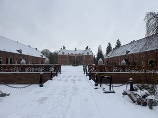 A grand historic Dutch castle, Kasteel Slangenburg, under rare snow.