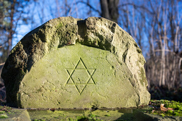 Stary zniszczony fragment żydowskiego nagrobka na opuszczonym i zapomnianym cmentarzu 