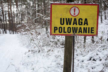Zimowe polowanie w lesie - tabliczka ostrzegająca potencjalnych przypadkowych spacerowicz&oacute;w przed niebezpieczeństwem